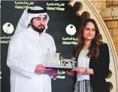  ?? Arshad Ali/Gulf News ?? Shaikh Ahmad Bin Mohammad presents the ‘Best Article in English’ to Jumana Khamis of Gulf News at the ceremony.