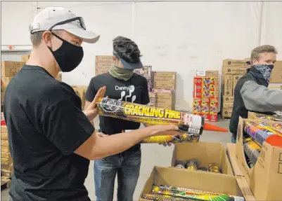  ?? Elizabeth Page Brumley Las Vegas Review-journal @Elipagepho­to ?? Jacob Kissman, 22, left, Brian Peveler, 15, and Cole Mattoon, 20, shop for fireworks at the Moapa Paiute Travel Plaza.