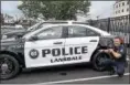  ?? SUBMITTED PHOTO— COURTESY OF LANSDALE BOROUGH POLICE DEPARTMENT ?? Lansdale police Officer John Albany poses next to one of the department’s patrol cars.