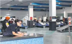  ??  ?? BIG HAUL: Australian Border Force officers Johsac Burns and Louise Officer dispose of seized tobacco products at the Cairns Internatio­nal Airport and (right) staff at the terminal.