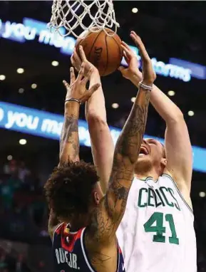  ?? AFP PIC ?? Celtics’ Kelly Olynyk (right) takes a shot with Wizards’ Kelly Oubre Jr. defending in their game in Boston on Wednesday.