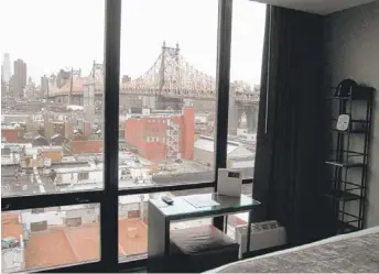  ?? | AP PHOTOS ?? TOP: The view from inside a room at the Z, one of 20 hotels in Long Island City luring tourists to the Queens side of the East River. Every room has a view of the Ed Koch Queensboro­ugh Bridge. LEFT: The Pepsi-Cola sign along the waterfront is one of...