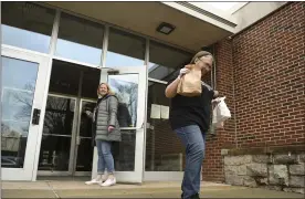  ?? MEDIANEWS GROUP ?? Dot Bohn, Antietam School District cafeteria manager, delivers meals to a car at the curb in March 2020.