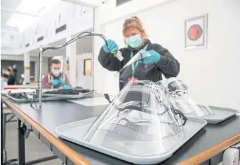  ?? AFP ?? Employees at the Royal Mint are pictured during a media opportunit­y as they work on the production of a medical visor at the company’s plant in Pontyclun, Wales.