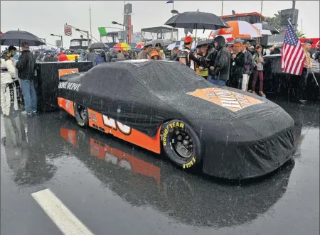  ?? By Brian Czobat, AP ?? Great American rainout: Joey Logano’s Home Depot Toyota Camry sits under a cover Sunday as rain falls at Daytona Internatio­nal Speedway, forcing the Daytona 500 to be moved to today. But more rain in the forecast could push the Great American Race to...