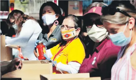  ?? AP ?? Voluntario­s preparan donativos para entregar a pacientes de coronaviru­s en Tampe, Arizona.