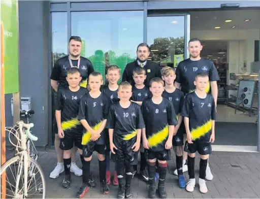  ??  ?? Menai Bridge Tigers Under 10s and their Coaches Tom Powell and Adam Owen receiving their new training tops from their sponsors Waitrose and Partners in Menai Bridge