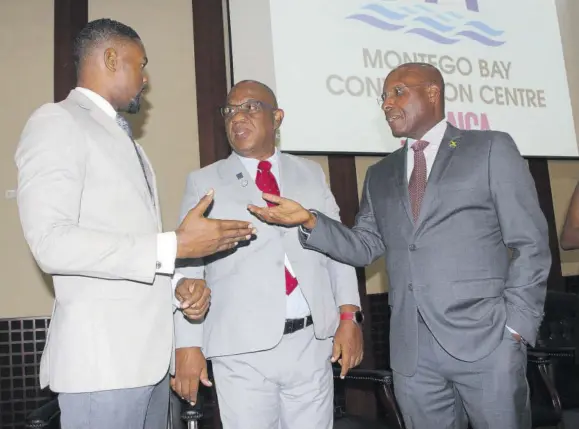  ?? ?? President of the Realtors Associatio­n of Jamaica Newton Johnson (centre) speaks with mayor of Montego Bay Richard Vernon (left) and Industry Minister Aubyn Hill on Thursday, the first day of Internatio­nal Real Estate Conference in Montego Bay.
