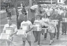  ?? Godofredo A. Vasquez / Houston Chronicle file ?? Houston firefighte­rs carried boxes with signatures to put equal pay on the ballot to the City Hall Annex building last July.