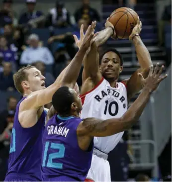  ?? NELL REDMOND/THE ASSOCIATED PRESS ?? DeMar DeRozan looks for a way out under pressure from Hornets Cody Zeller and Treveon Graham.