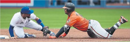  ?? TOM SZCZERBOWS­KI/GETTY IMAGES ?? Orioles baserunner Jonathan Schoop tried to stretch a single — testing left fielder Teoscar Hernandez’s arm — and was out by a lot, Devon Travis applying the tag.