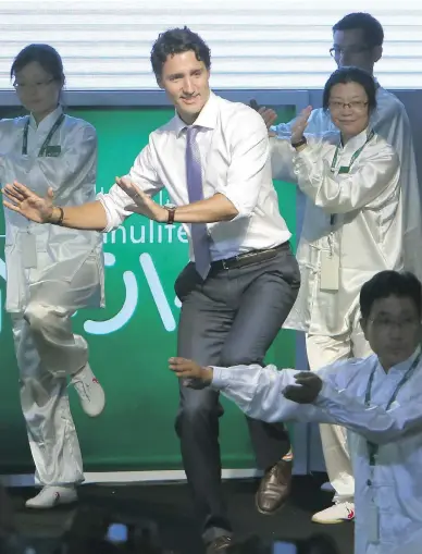  ?? CHINATOPIX VIA THE ASSOCIATED PRESS ?? Prime Minister Justin Trudeau performs tai chi with performers in Shanghai on Friday. His trip ahead of the G20 summit has been full of photo ops, but questions persist about the Liberal government’s strategic vision for China.