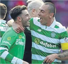  ??  ?? Celtic captain Scott Brown (right) and team-mate Patrick Roberts celebrate winning the league at Tynecastle.