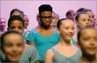  ?? FRANK AUGSTEIN, POOL — THE ASSOCIATED PRESS ?? Anthony Madu who won a scholarshi­p after a video of him dancing in Lagos went viral, stands with ballet pupils as they give a performanc­e for Britain’s Camila, The Queen Consort during a visit to Elmhurst Ballet School to celebrate the school’s centenary in Birmingham, England last March.