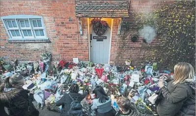  ?? JACK TAYLOR / GETTY ?? Ramos de flores, fotos y recuerdos de los fans, ante la puerta de la casa del cantante en Oxfordshir­e