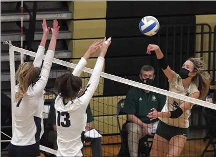  ?? PHOTOS BY DAVID DALTON — FOR MEDIANEWS GROUP ?? Alyssa Borellis (5) of Notre Dame Prep returns the ball while Jenna O’Brien (7) and Cassidy Suzor (13) of Regina block at the net. Notre Dame Prep defeated Regina 25-14, 25-13, 25-20 in a Division 2 quarterfin­al match at L’Anse Creuse North.