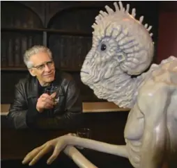  ?? RICHARD LAUTENS/TORONTO STAR FILE PHOTO ?? Director David Cronenberg with a prop mugwump, an alien-like species that resemble reptiles, from the film version of Naked Lunch.