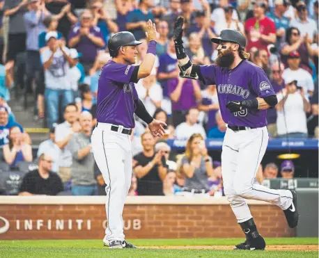  ?? Kelsey Brunner, The Denver Post ?? Rockies right fielder Charlie Blackmon celebrates with teammate Pat Valaika after hitting a two-run homer during the third inning Saturday night at Coors Field against the Los Angeles Dodgers.