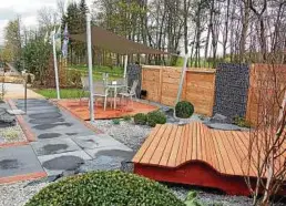  ??  ?? Zwischen Friedenste­ich und Blumenscha­uhalle laden im „Grünen Wohnzimmer“des Eisenberge­r Gartenbaub­etriebes Rosenkranz ein luftiger Sitzplatz und eine riesige Holzliege zum Verweilen und Ausruhen ein.