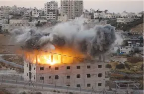  ?? (Mussa Qawasma/Reuters) ?? A PALESTINIA­N BUILDING is demolished by the IDF in Wadi al-Hummus, which sits on either side of the Israeli barrier just outside of Jerusalem in the West Bank.