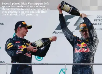  ??  ?? Second placed Max Verstappen, left, sprays teammate and race winner Daniel Ricciardo with champagne as they celebrate on the podium after the Malaysian GP yesterday
