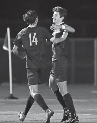  ?? SEAN D. ELLIOT ?? Stonington forward Sam Montalto, right, is congratula­ted by teammate Billy DeCastro (14) after scoring his first goal on a penalty kick to break the Bears’ career goal scoring record on Friday night in a 5-1 win over Ledyard.