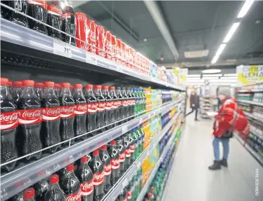  ??  ?? A customer browses a display of soft drinks including Coca-Cola Co products inside a Perekresto­k supermarke­t, operated by X5 Retail Group NV in Moscow on Wednesday.