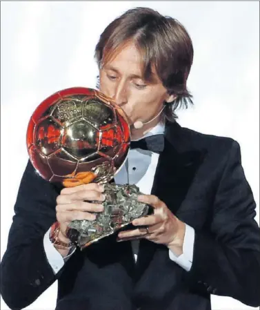  ??  ?? FELIZ. Modric besa el Balón de Oro que le consagra como mejor jugador de 2018.