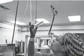  ??  ?? Denisha Washington, lab technician at Transnetyx, works with samples at Transnetyx in Cordova on Jan. 22. Tranxnetyx provides outsourced genotyping services and can detect mutations in mice, zebrafish, rabbits, ferrets, goats and rats. BRAD VEST/THE COMMERCIAL APPEAL