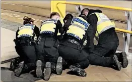  ?? SAM CLACK/AP ?? Police restrain a man after he stabbed three people at Victoria Station in Manchester, England, late Monday. Three were severely injured in the attack.
