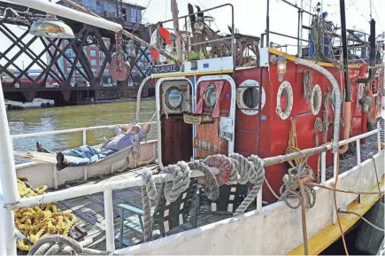  ??  ?? Mark Gubin relaxes in a hammock on the rear deck of his historic Milwaukee tugboat, the Solomon Juneau. The boat is tied up at Jerry's Dock, 318 S. Water St. Gubin hangs out on the boat many days and has held many parties on its decks.