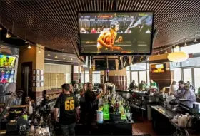  ?? Michael M. Santiago/Post-Gazette ?? People enjoy early-afternoon drinks Saturday at Jerome Bettis' Grille 36 on the North Shore. The cancellati­on of sports and the annual St. Patrick's Day parade because of the COVID-19 pandemic has left many businesses with far fewer customers than usual.