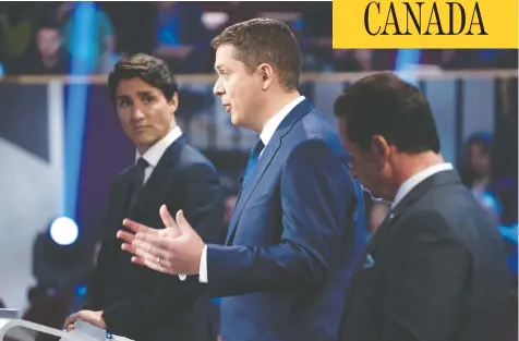  ?? CHRIS WATTIE / THE CANADIAN PRESS ?? Justin Trudeau watches as Andrew Scheer makes a point at the final French language debate in Gatineau on Thursday night.