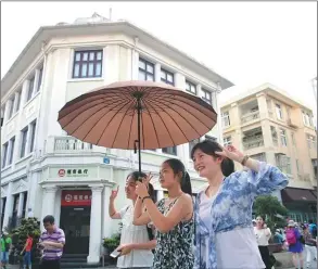  ??  ?? Tourists walk down a street on Gulangyu Island.