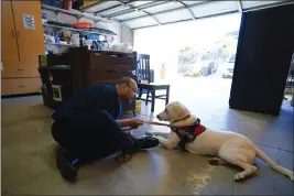  ?? ?? Adam Holwuttle, 35, spends time training Apollo in the garage at Merakey center on Jan. 27in Escondido. Holwuttle along with his housemates, have been working with Apollo's training before they can place him for adoption.