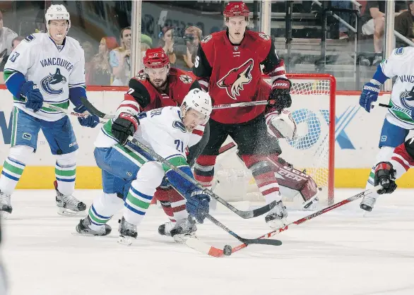  ?? NORM HALL/NHLI VIA GETTY IMAGES ?? Brandon Sutter of the Vancouver Canucks and Brad Richardson of the Arizona Coyotes battle for the puck at Gila River Arena in Glendale, Ariz. on Friday.