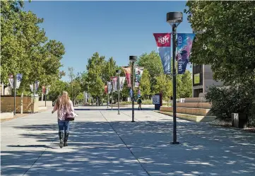  ?? GABRIELA CAMPOS/NEW MEXICAN FILE PHOTO ?? A student walks through the University of New Mexico campus in September 2020. Many young students are facing the highest college prices of all time, according to Forbes.