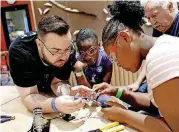  ?? [PHOTO PROVIDED] ?? A Science Museum Oklahoma staff member assists guests with soldering during the 2017 Tinkerfest.