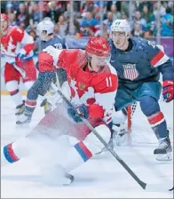  ?? JIM YOUNG / REUTERS ?? Russia’s Yevgeni Malkin spins away from Team USA’s Ryan McDonagh during the first period of their preliminar­y round ice hockey game at the Sochi Olympics on Saturday.