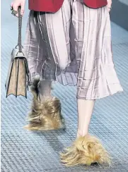  ??  ?? A model wears footwear with wisps of fur as part of the Gucci women’s autumn-winter 2015-2016 collection.