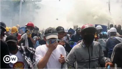  ??  ?? Protesters in Mandalay move clear of a cloud of tear gas launched by security forces