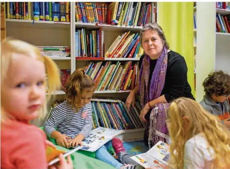  ?? FOTO: OLIVER DIETZE ?? Steffi Ludwig, umgeben von den Kindern vom Theresienh­eim, die auf dem Leseteppic­h in Bilderbüch­ern stöbern.