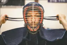  ?? NATHAN BURTON/Taos News ?? Lead instructor Aaron Garlick ties hties his men (traditiona­l Japanese helmet) during kendo practice on Friday (March 18).