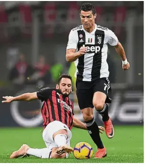  ?? — AFP ?? On fire: Juventus’ Cristiano Ronaldo dribbling past AC Milan’s Hakan Calhanoglu during the Serie A match at the San Siro on Sunday.