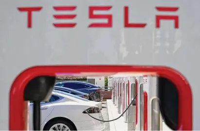  ?? Godofredo A. Vásquez/Associated Press file photo ?? Tesla vehicles charge at a station in Emeryville, Calif. Tesla will, for the first time, make some of its charging stations available to all U.S. electric vehicles by the end of next year under a new plan announced by the White House.