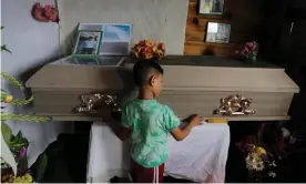  ??  ?? A child touches the coffin of Nelson Espinal, who was shot dead outside his home on 18 December 2018 in Tegucigalp­a, Honduras. Photograph: Jorge Cabrera/Reuters