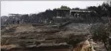  ?? AP PHOTO/THANASSIS STAVRAKIS ?? In this file photo dated July 24, firefighte­rs stand on the cliff top where burned trees hug the coastline in Mati east of Athens, after wildfires raged through the popular seaside areas near the Greek capital.