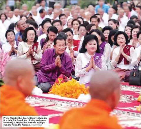  ?? HONG MENEA ?? Prime Minister Hun Sen (left) prays alongside first lady Bun Rany (right) during a religious ceremony at Angkor Wat meant to highlight stability within the Kingdom.