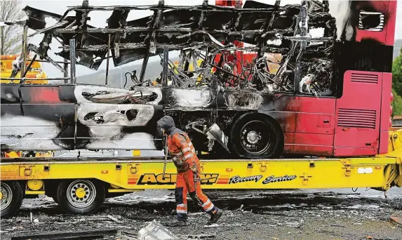  ?? FOTO ČTK/AP ?? V plamenech skončily za poslední dva týdny již dva autobusy. Maskovaným mužům, kteří je zapálili, údajně vadila severoirsk­á pojistka brexitové dohody.