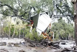  ??  ?? A structure is smashed against a tree along Hot Springs Road in Montecito, Calif. after getting hit by a flash flood and debris flow on Tuesday, Jan. 9, 2018. (Daniel Dreifuss)